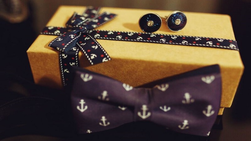 yellow gift box behind an anchor design violet bow tie